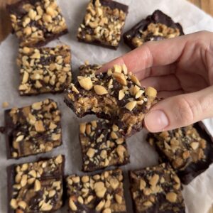 Snickerskaka med chokladbotten, krämigt jordnötssmör, mörk choklad och salta jordnötter.